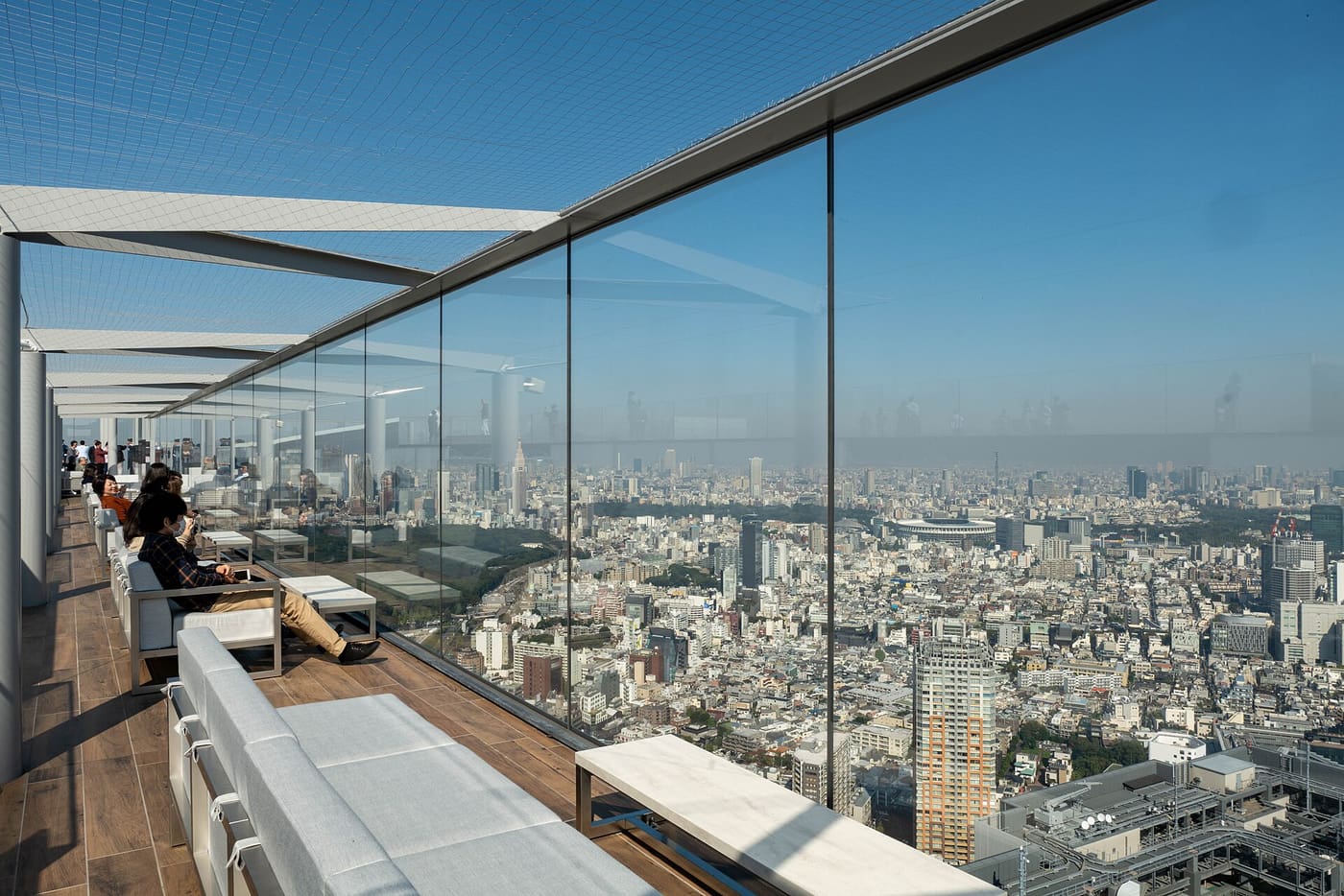 Visitors lounging on the Shibuya Sky rooftop with the city spread out below