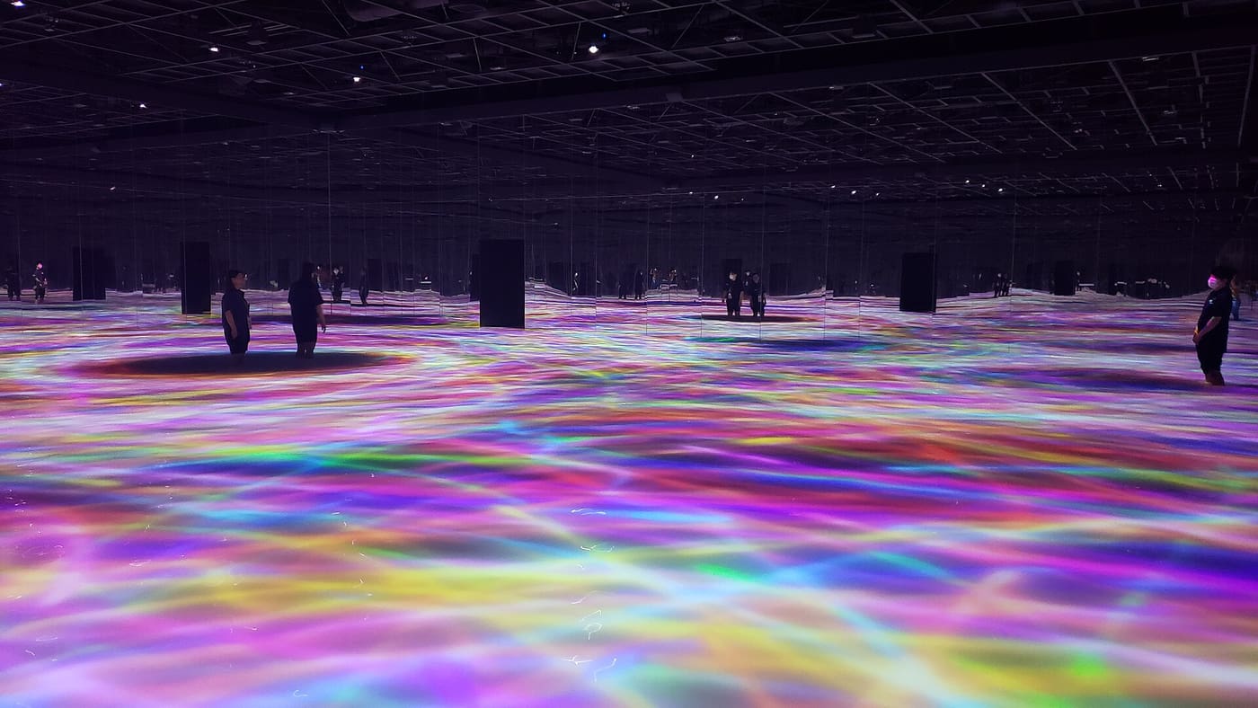 Visitors inside a glowing light installation at teamLab Planets in Toyosu