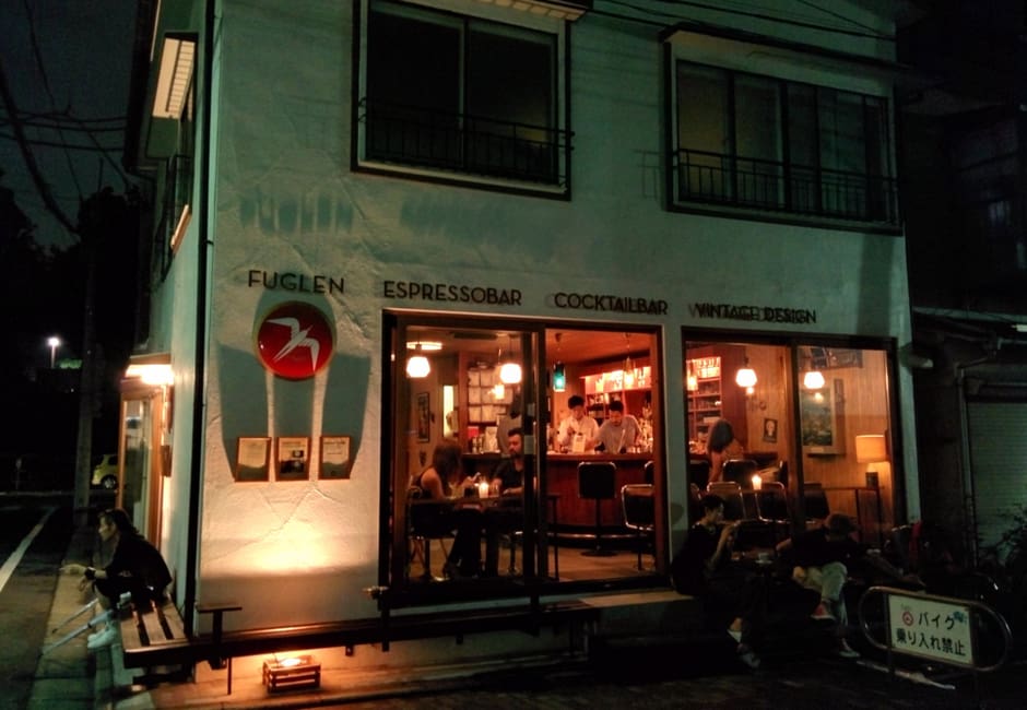 Fuglen Tokyo coffee bar glowing at night on a Tomigaya corner with its red bird sign