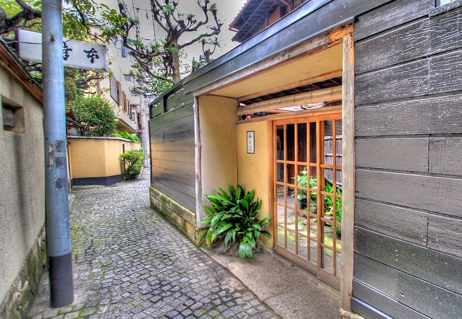 Hyogo Yokocho in Kagurazaka, a stone-paved lane between black wooden walls and a latticed inn entrance