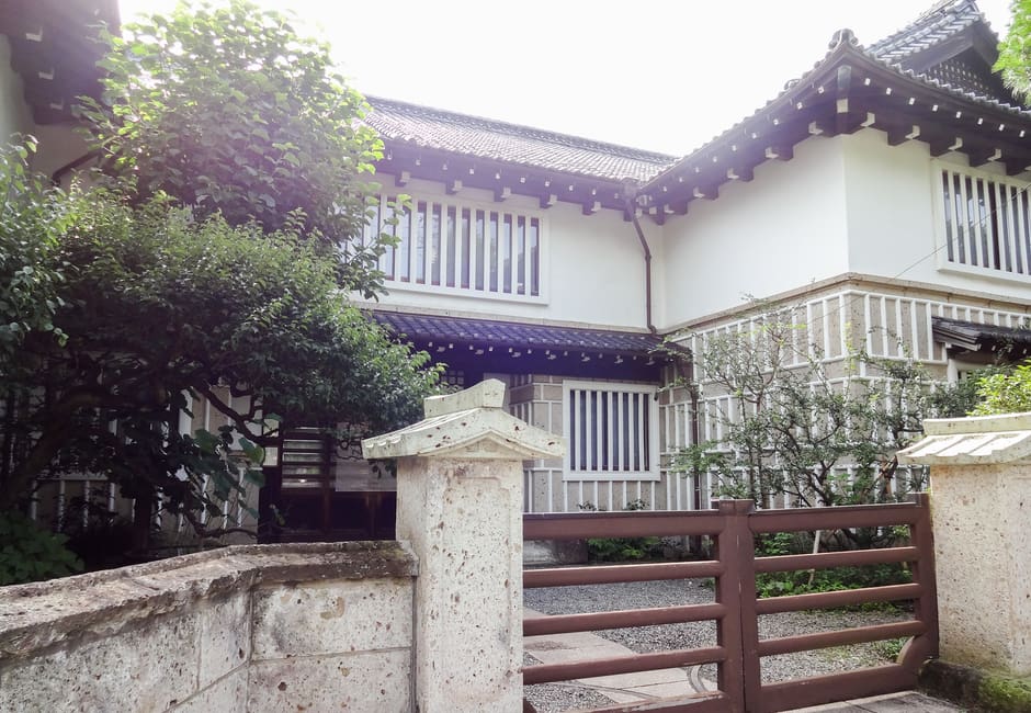 Stone gateway and white-walled building of the Japan Folk Crafts Museum, Mingeikan, in Komaba