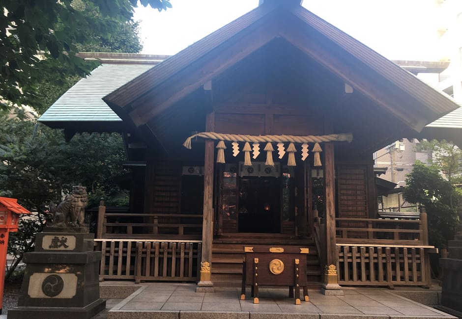 Dark wooden worship hall of Kuramae Shrine with shimenawa rope and stone guardians, Kuramae