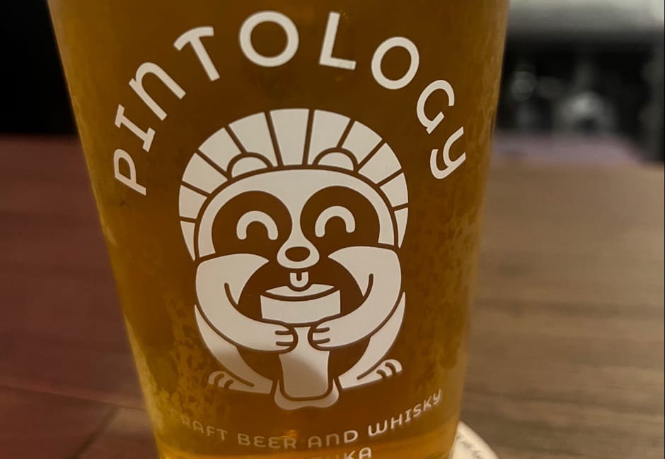 A pint of craft beer in a Pintology glass printed with the bar's tanuki logo, Sasazuka