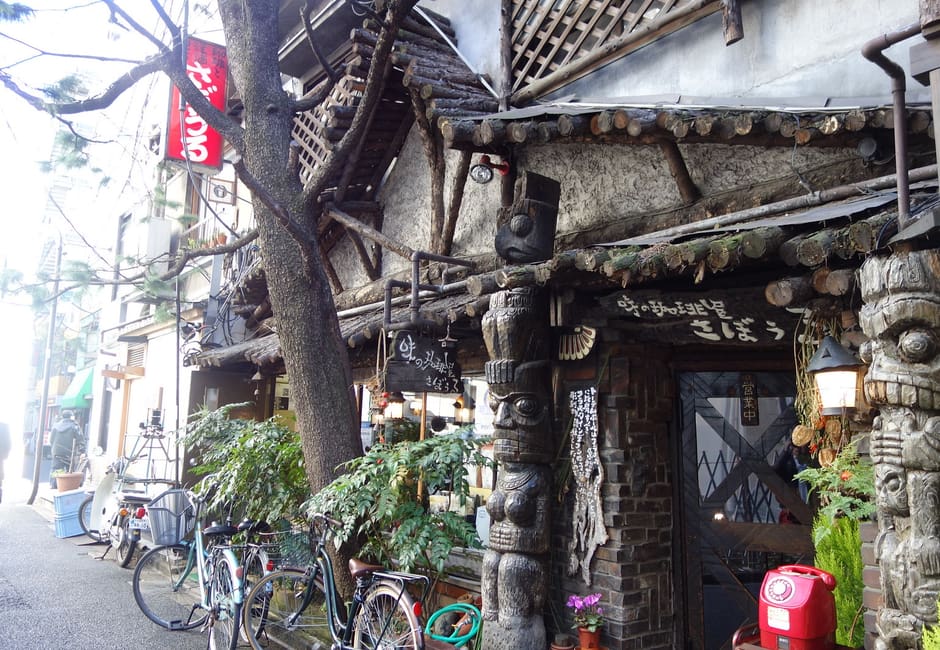 The ivy-covered front of Sabouru in Jimbocho, with its carved wooden totem pole by the door