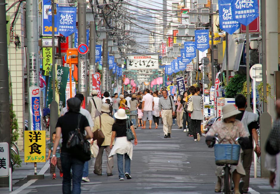 Shoppers walking the long Togoshi Ginza shopping street under hanging banners, Shinagawa