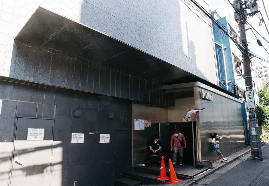 Dark concrete entrance of the Womb nightclub on a Shibuya side street