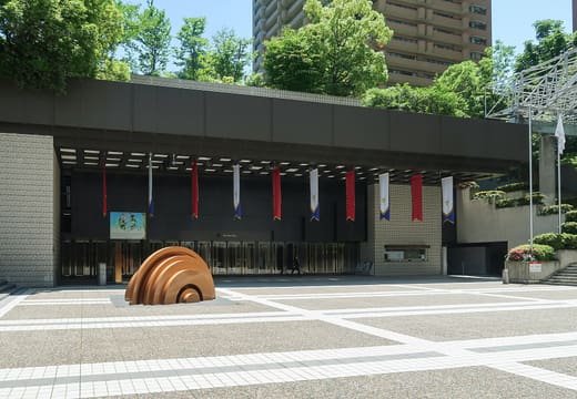 The entrance of Suntory Hall in Akasaka, seen across the paved plaza with its bronze sculpture
