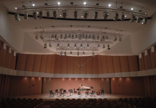 Empty stage and wood-panelled walls of the concert hall at Toppan Hall, Iidabashi